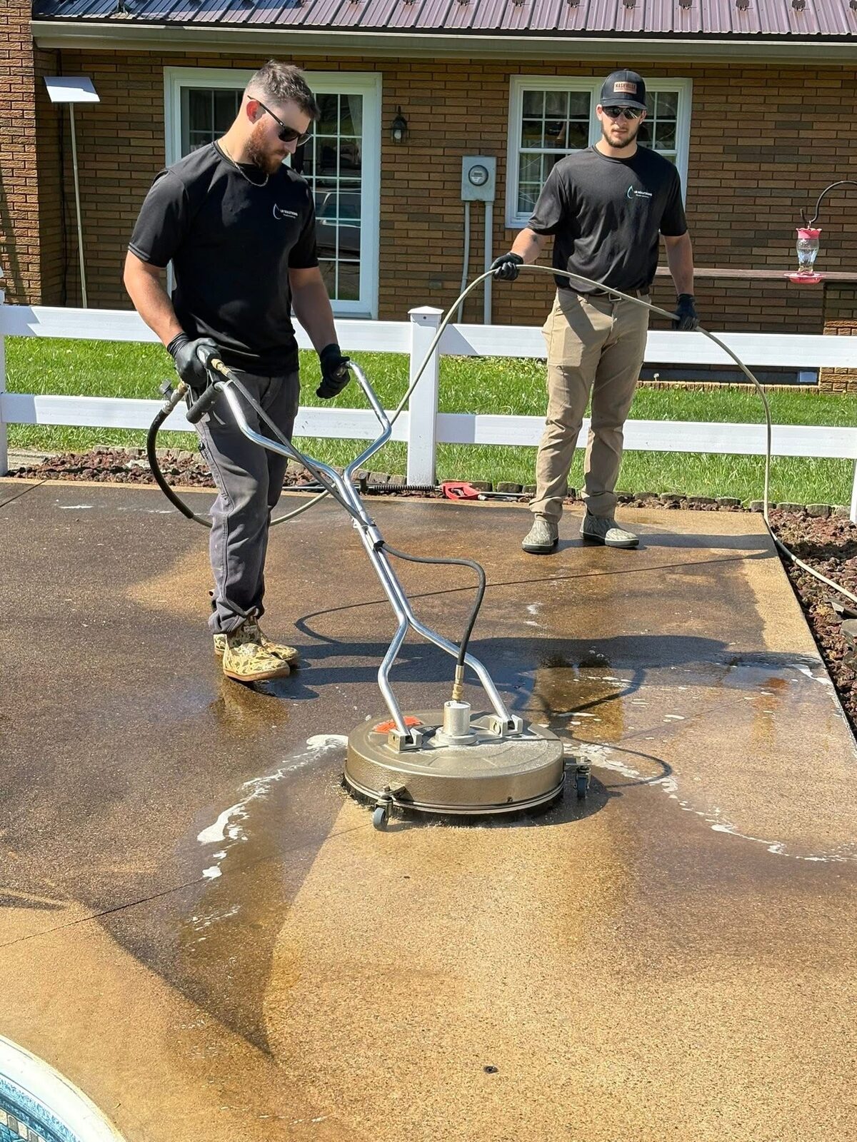 LR Solutions team using a surface cleaner on a residential walkway